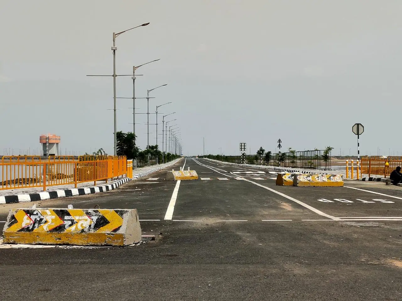 a road with yellow and white barriers Activation Area Dholera smart city gujrat Urban NXT Developers